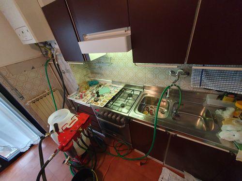 Una cucina con fornelli, lavello e tubo flessibile ad essa collegato.