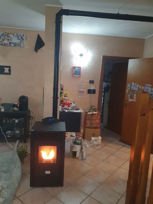 Una stanza con una stufa al centro