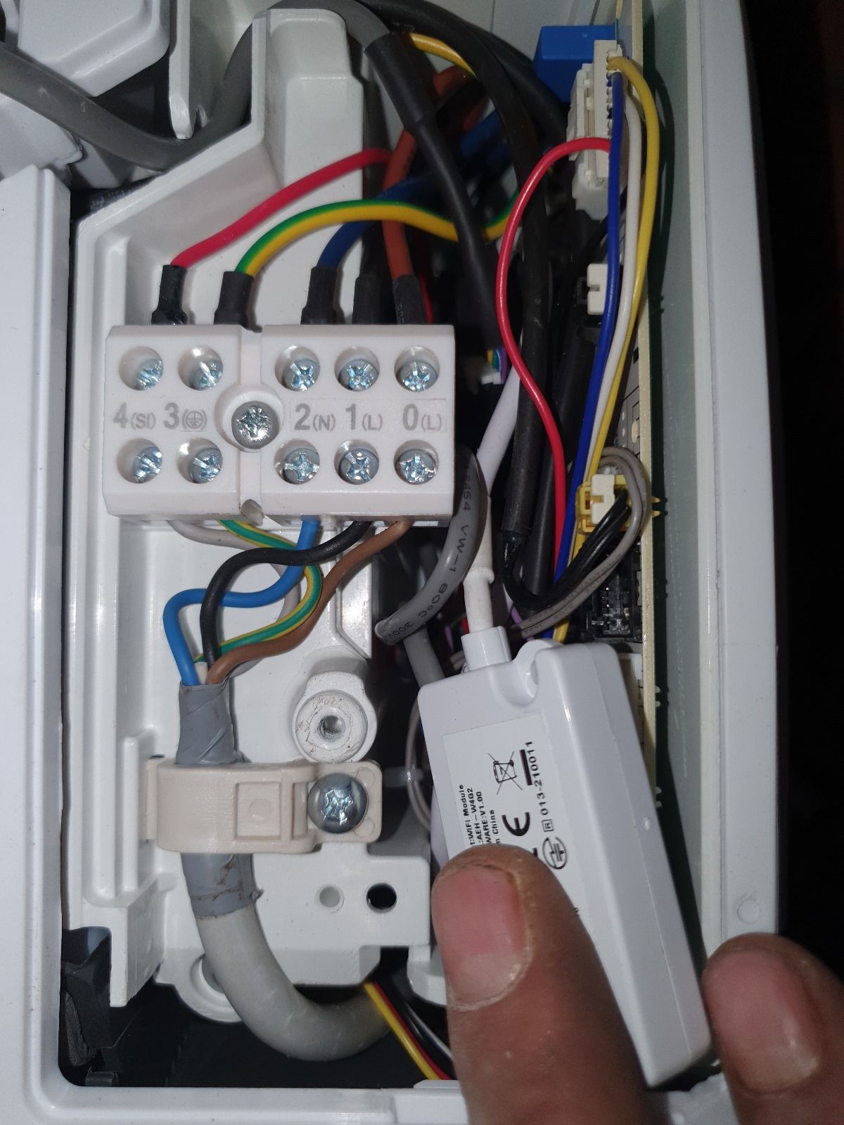 Una persona tiene in mano una scatola bianca da cui escono dei fili