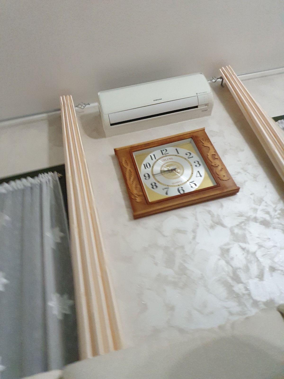 Un orologio è appeso a una parete accanto a un condizionatore.