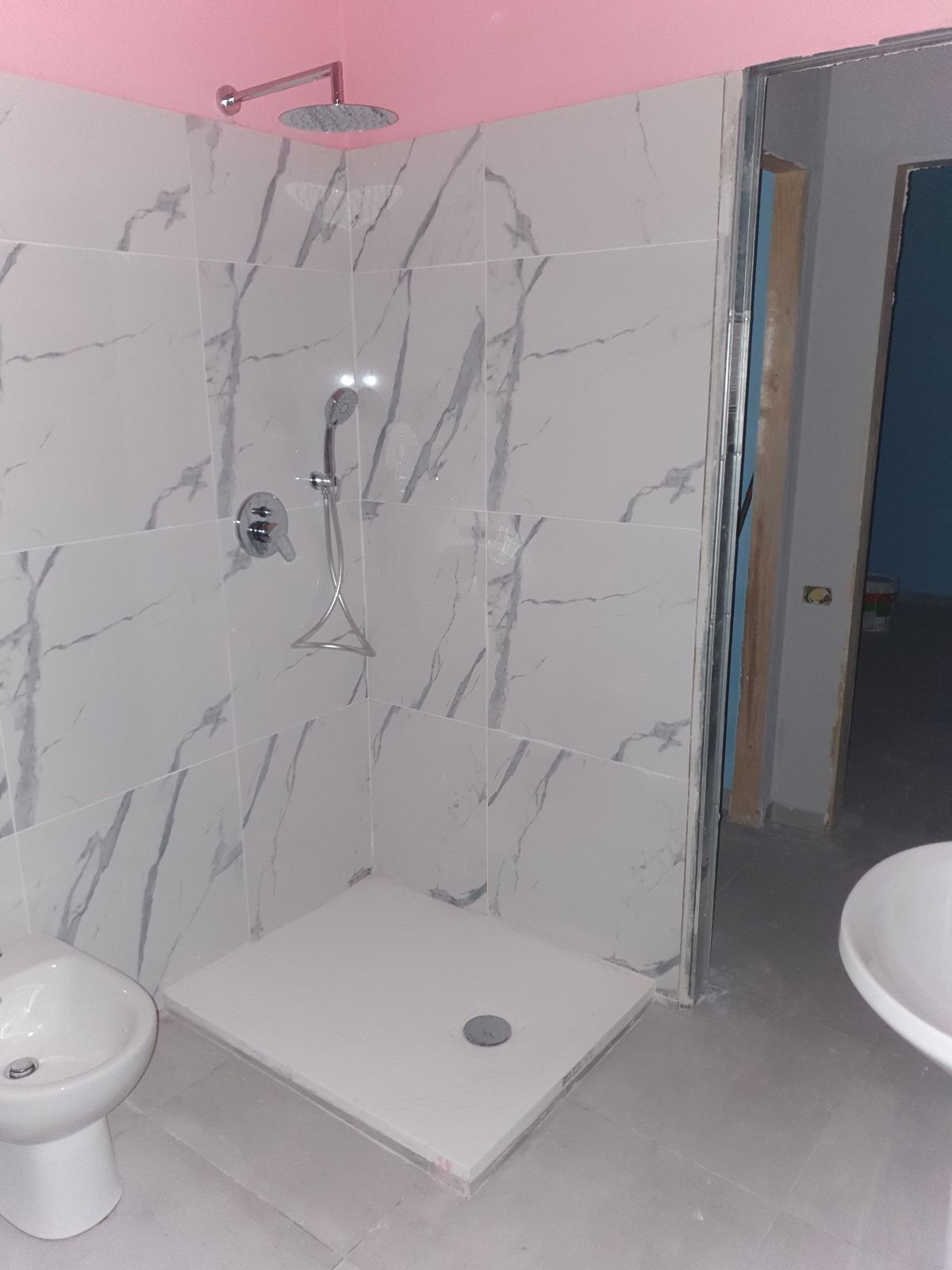 Un bagno con doccia, bidet e lavandino.