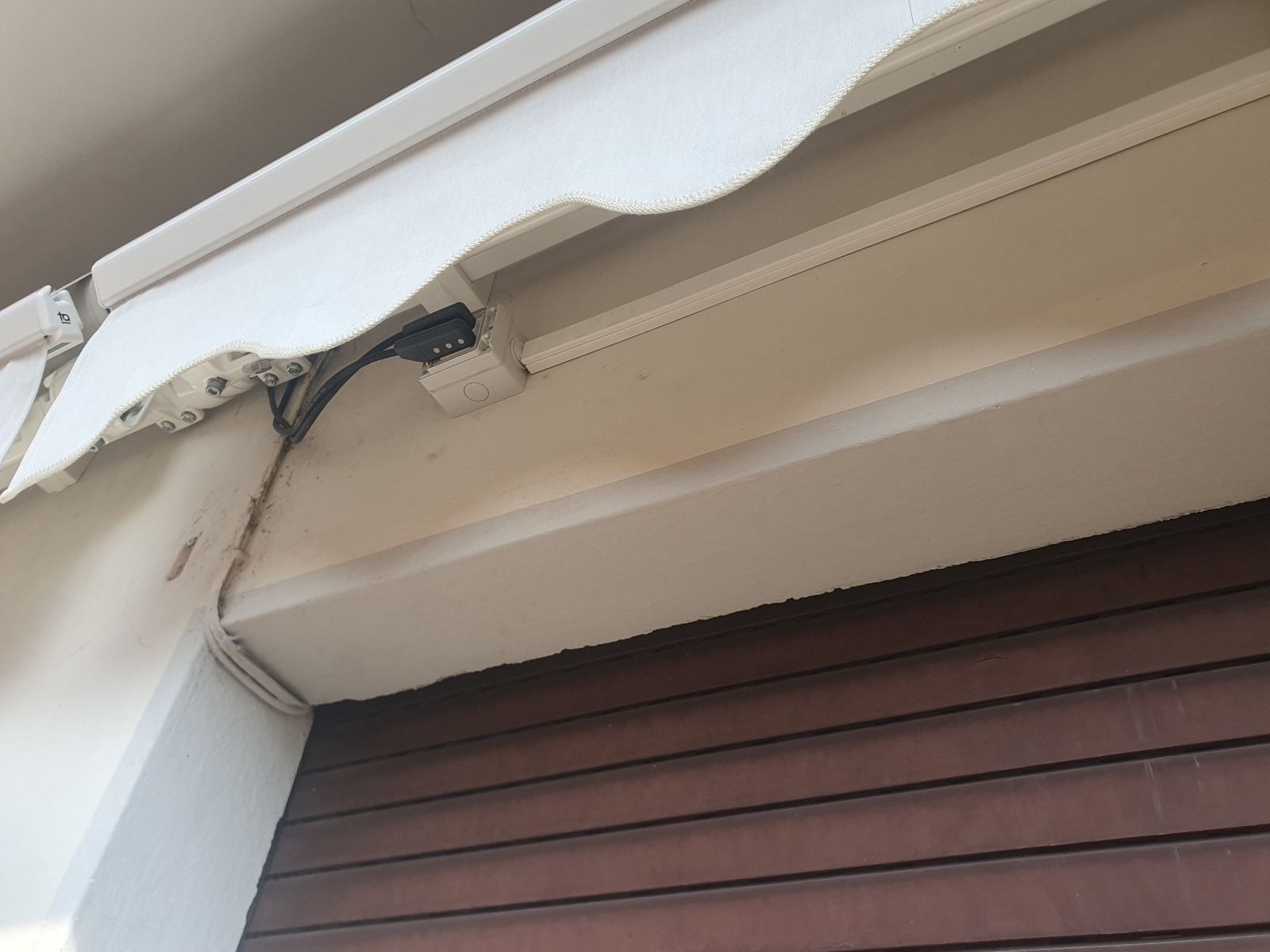 Una tenda bianca è appesa sopra una porta di legno