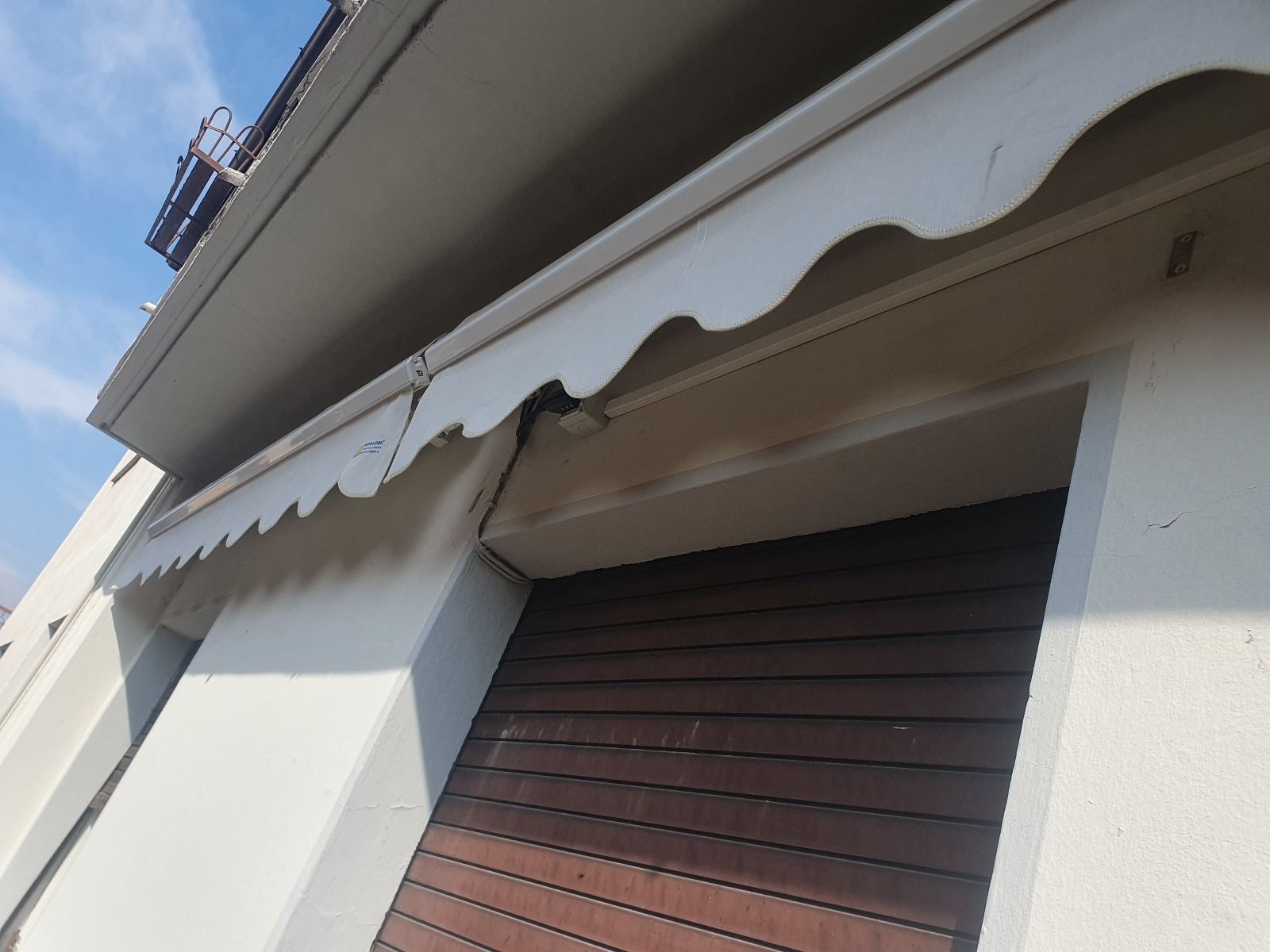 Una tenda bianca è appesa sopra una porta marrone