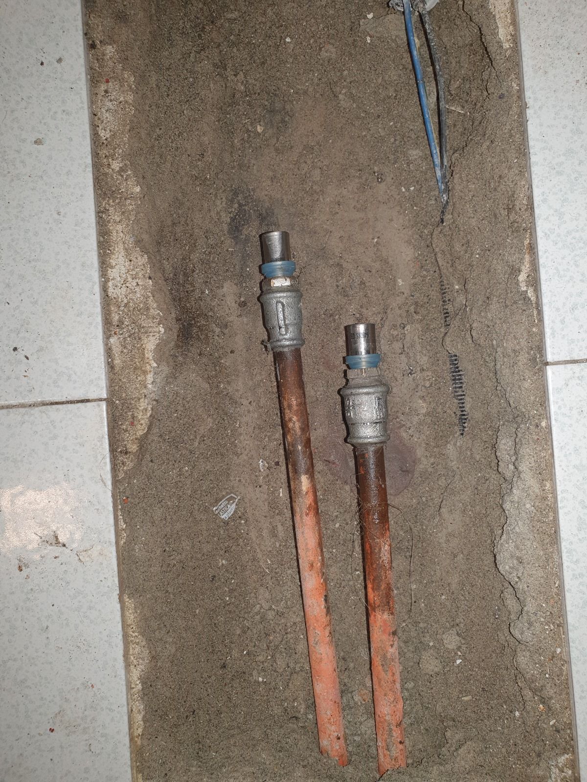 Due tubi di rame sono adagiati nella terra sul pavimento