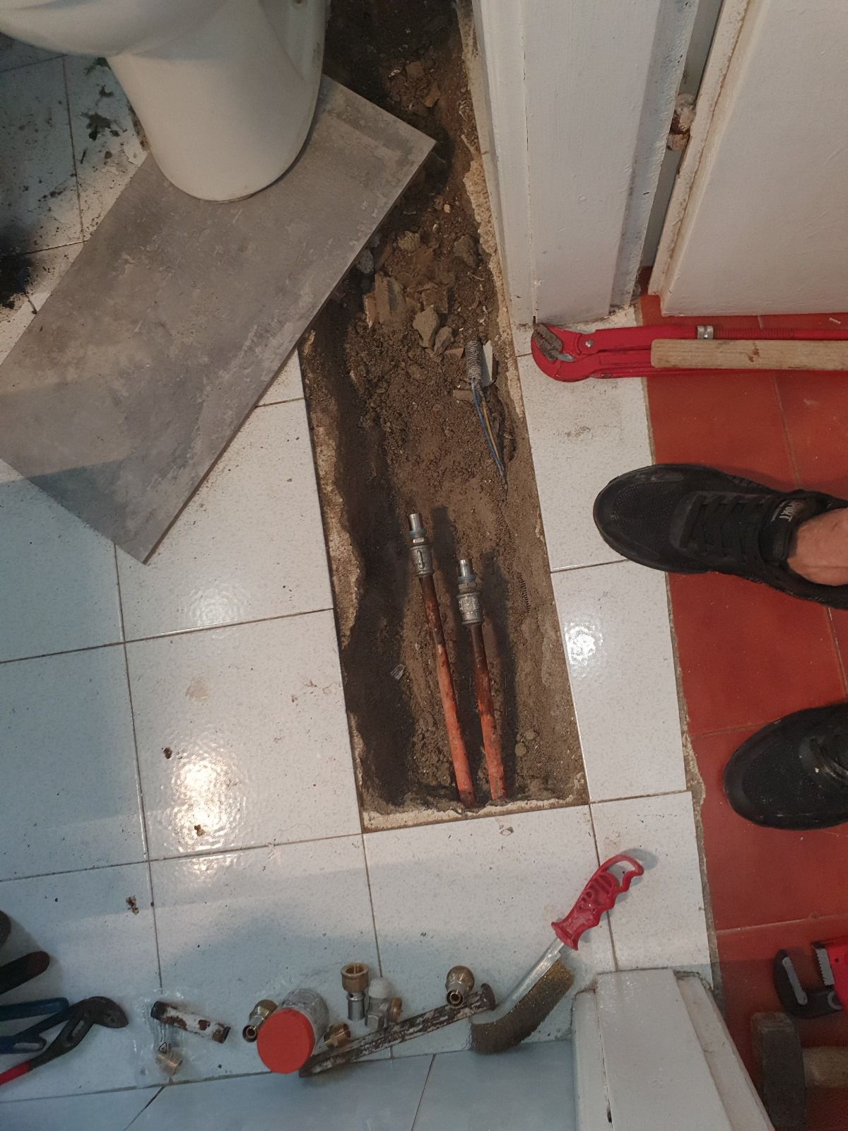 Una persona sta lavorando su un tubo in un bagno.