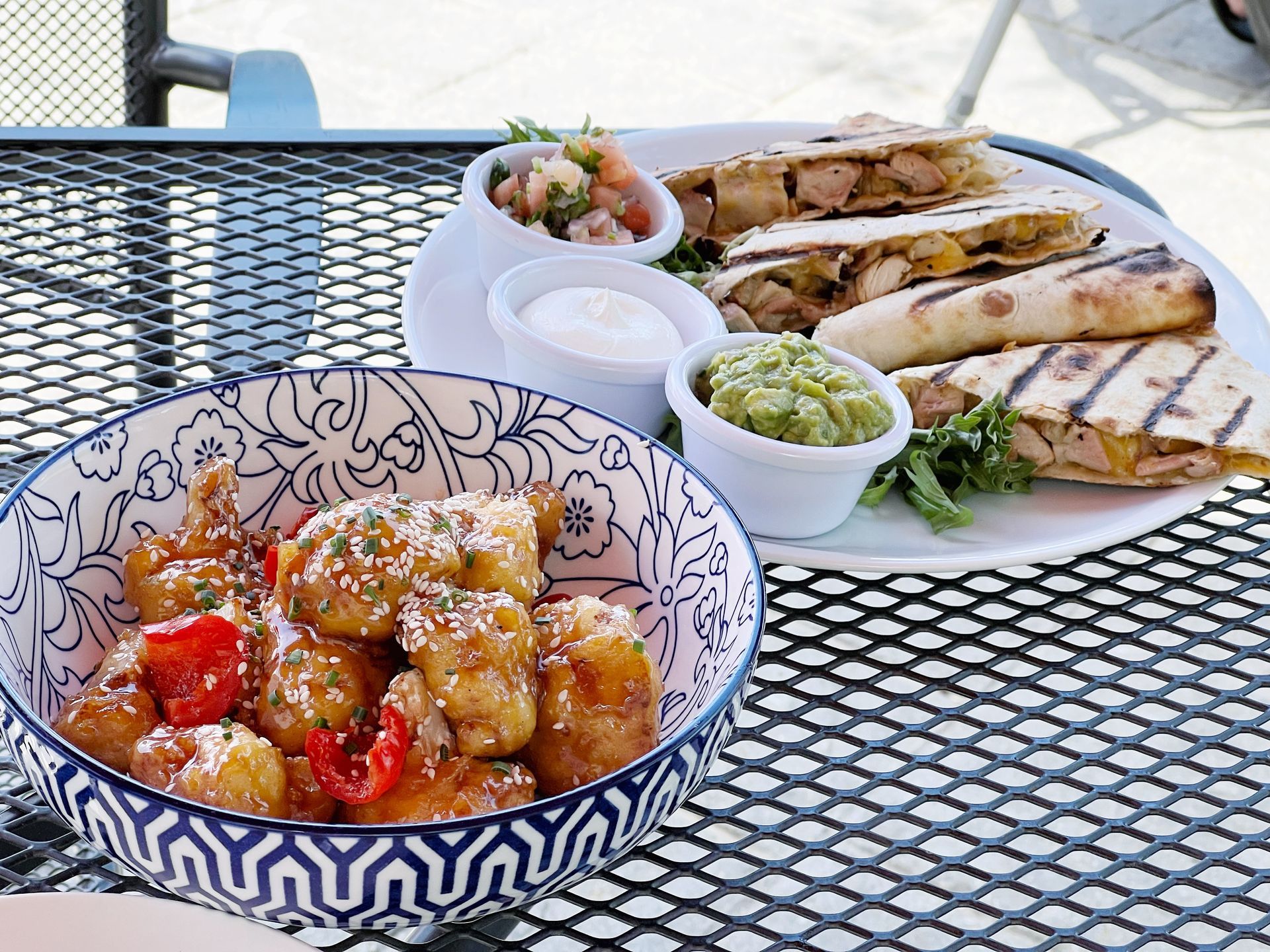 A plate of food and a bowl of food on a table.