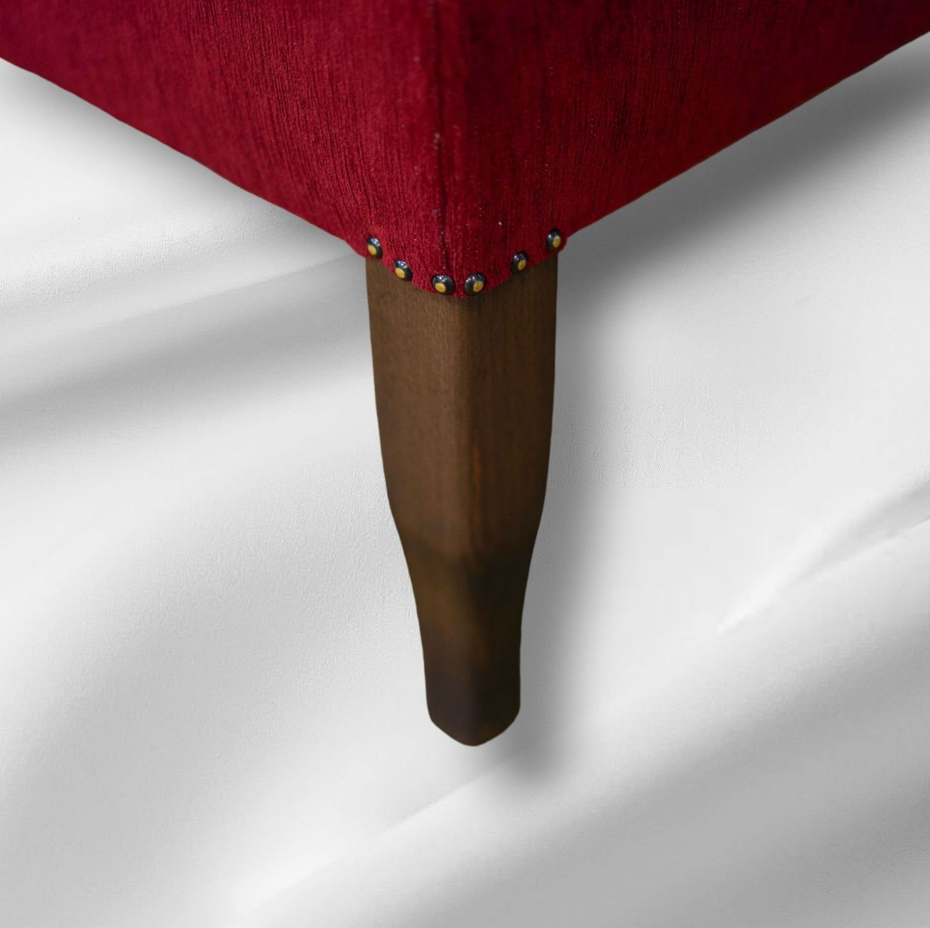 Eine Nahaufnahme eines roten Sofas mit Holzbeinen