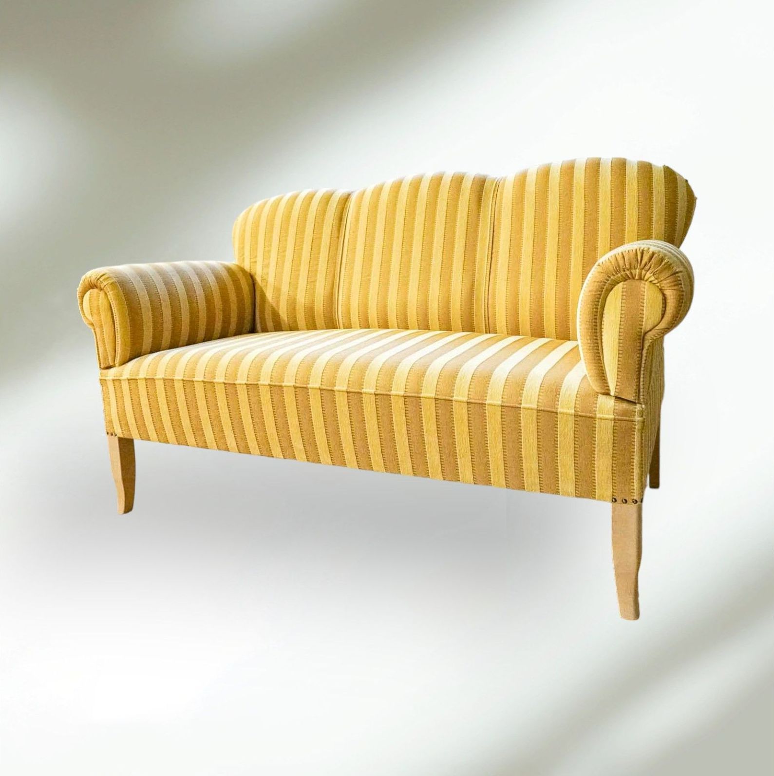 Ein gelb gestreiftes Sofa mit Holzbeinen