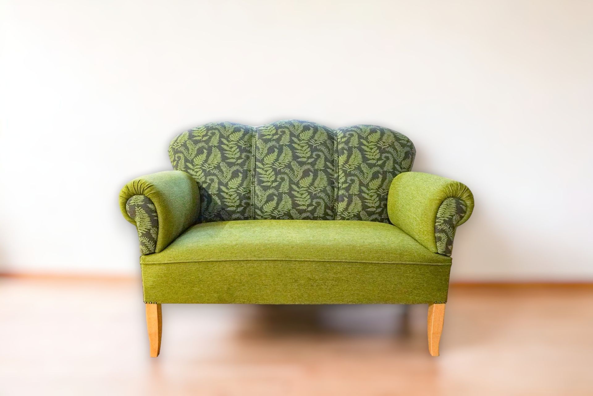 Ein grünes Sofa vor einer weißen Wand