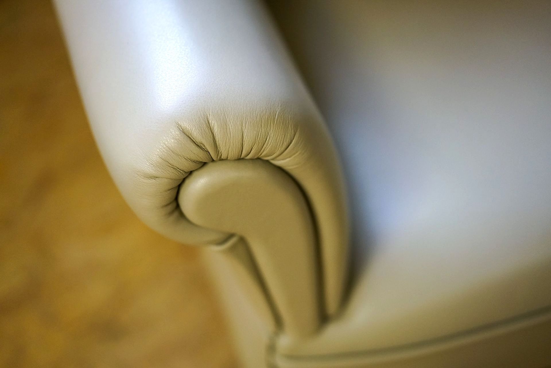 Eine Nahaufnahme der Armlehne eines weißen Ledersessels