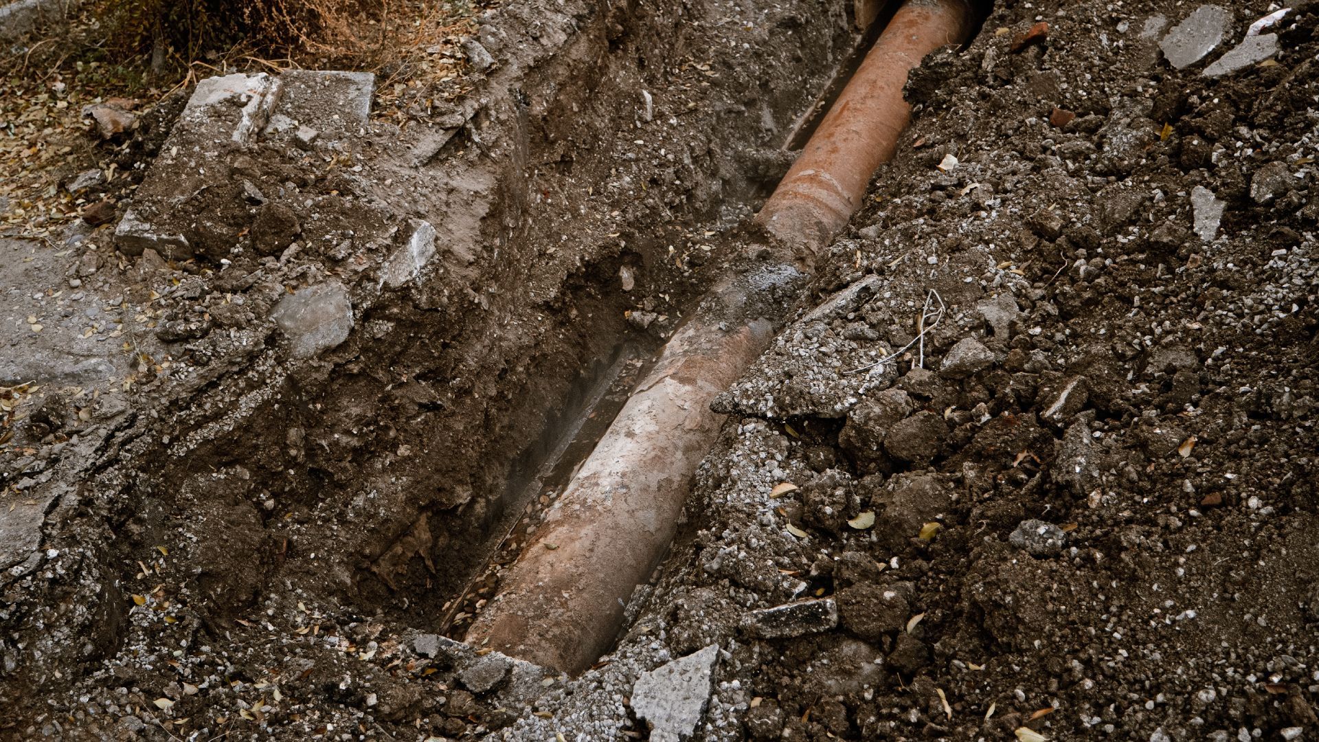 A pipe is coming out of the ground in the dirt.