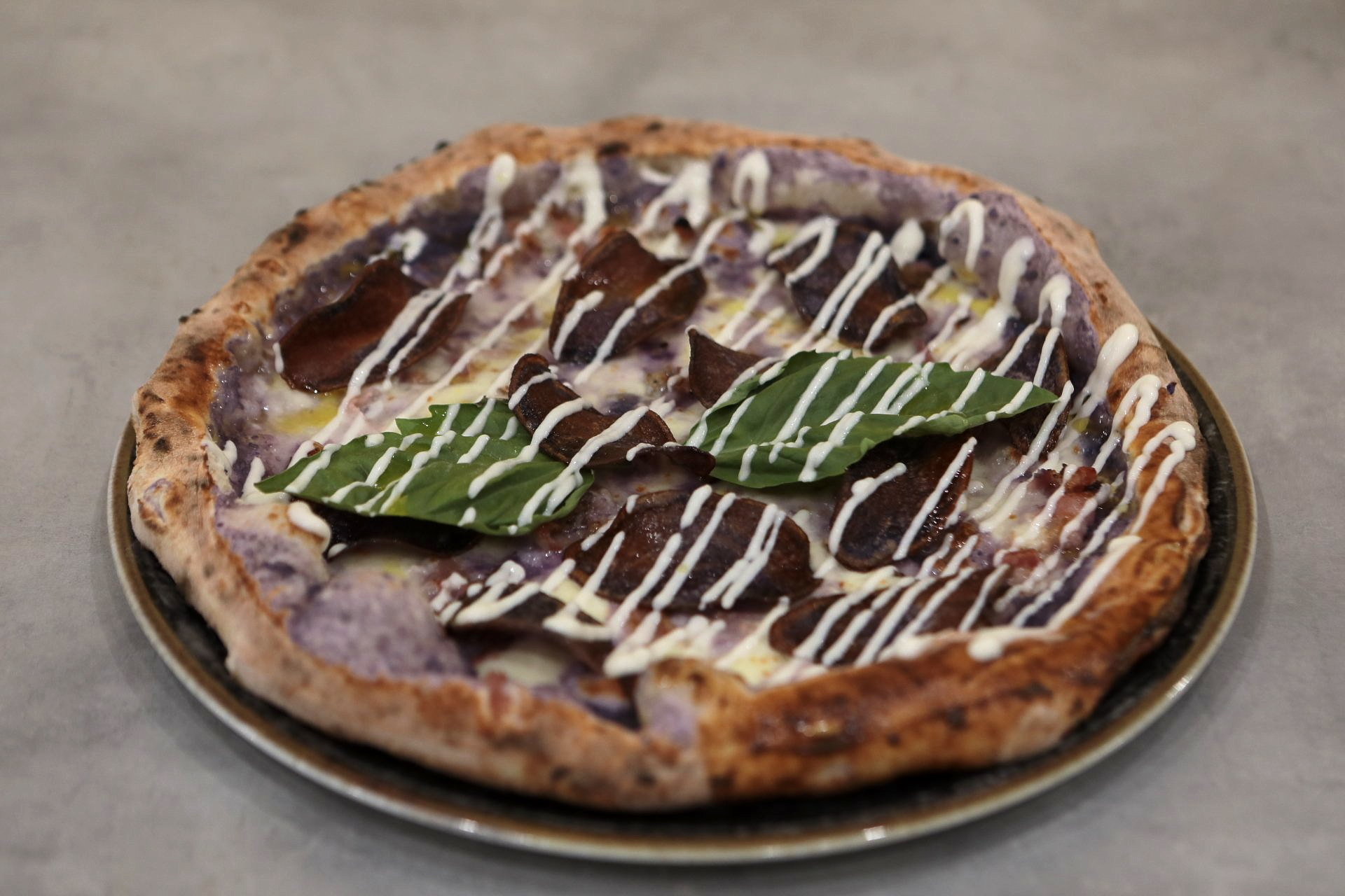 Una pizza con una foglia sopra, su un piatto.