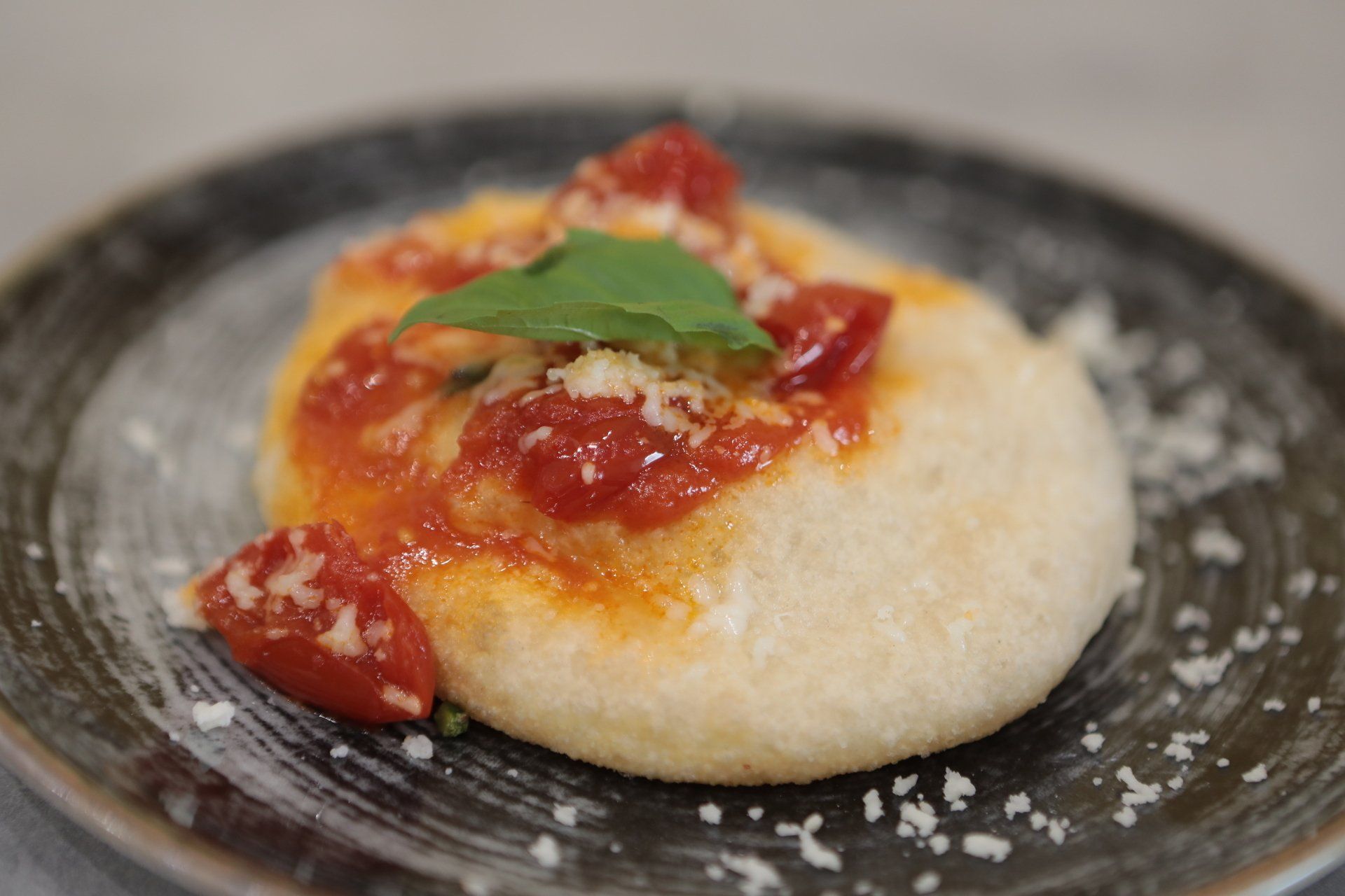 Primo piano di una pizza con salsa di pomodoro su un piatto.
