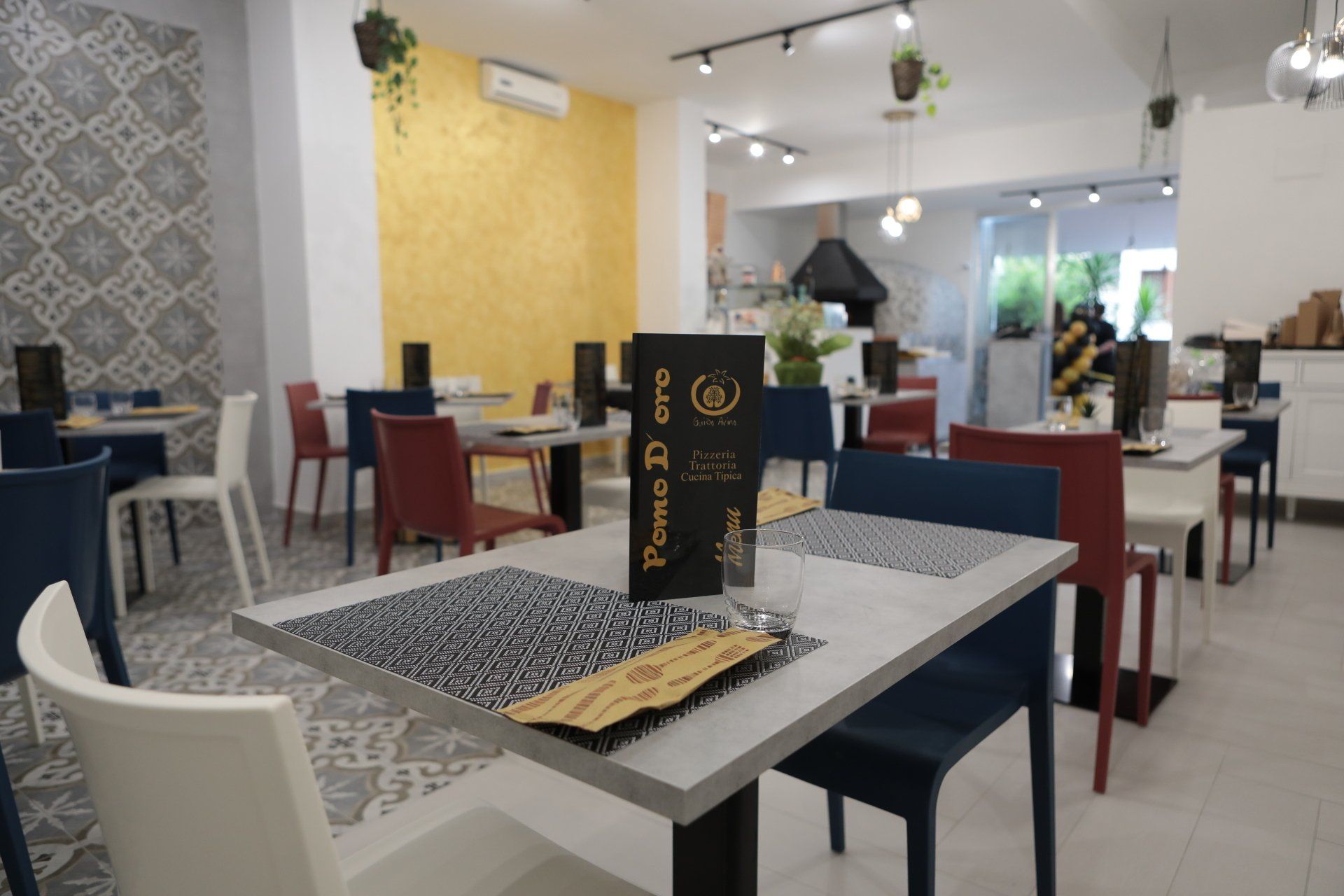 Un ristorante con tavoli e sedie e un menù sul tavolo.