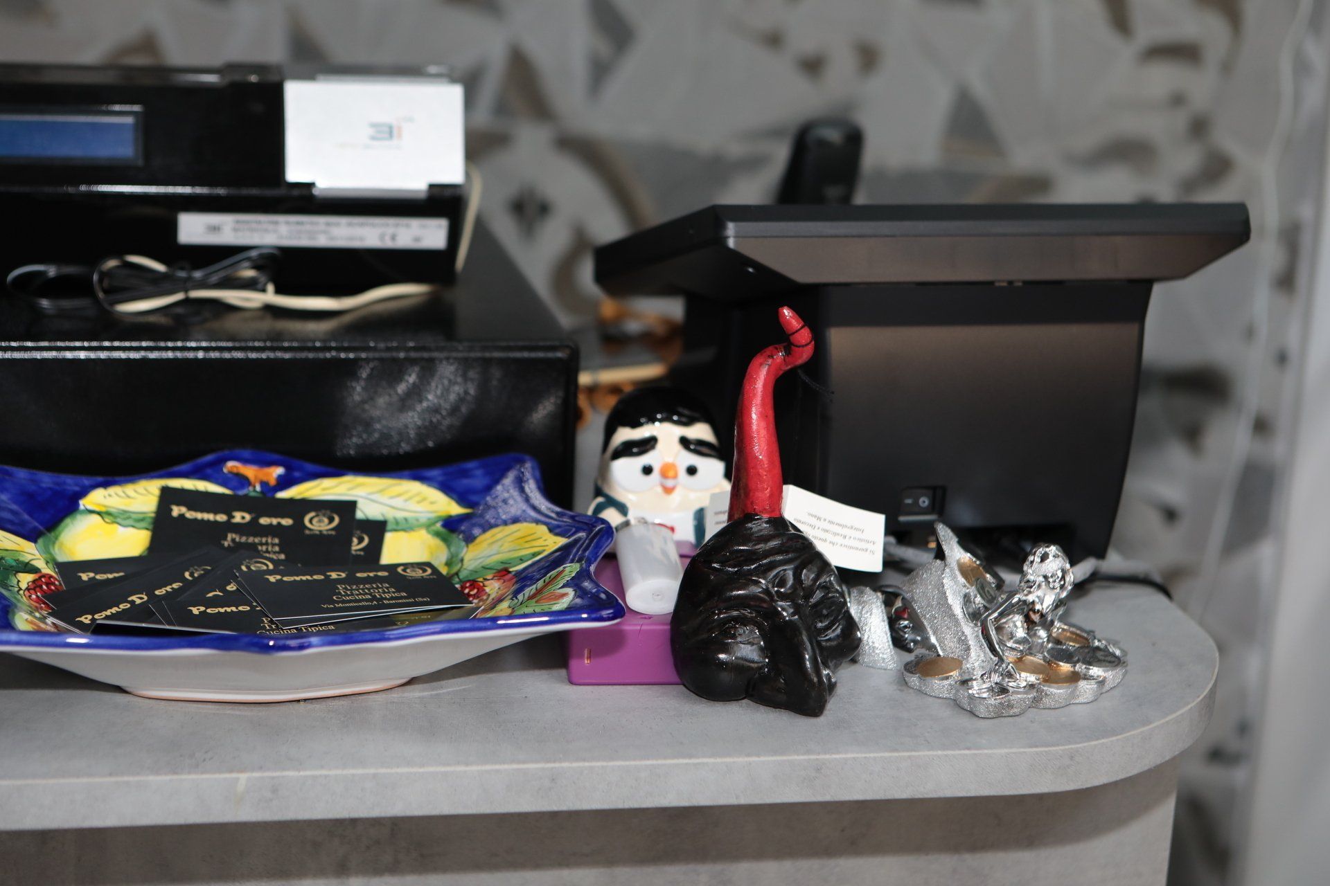 Una statuetta di pinguino è seduta su un bancone accanto a un monitor di computer