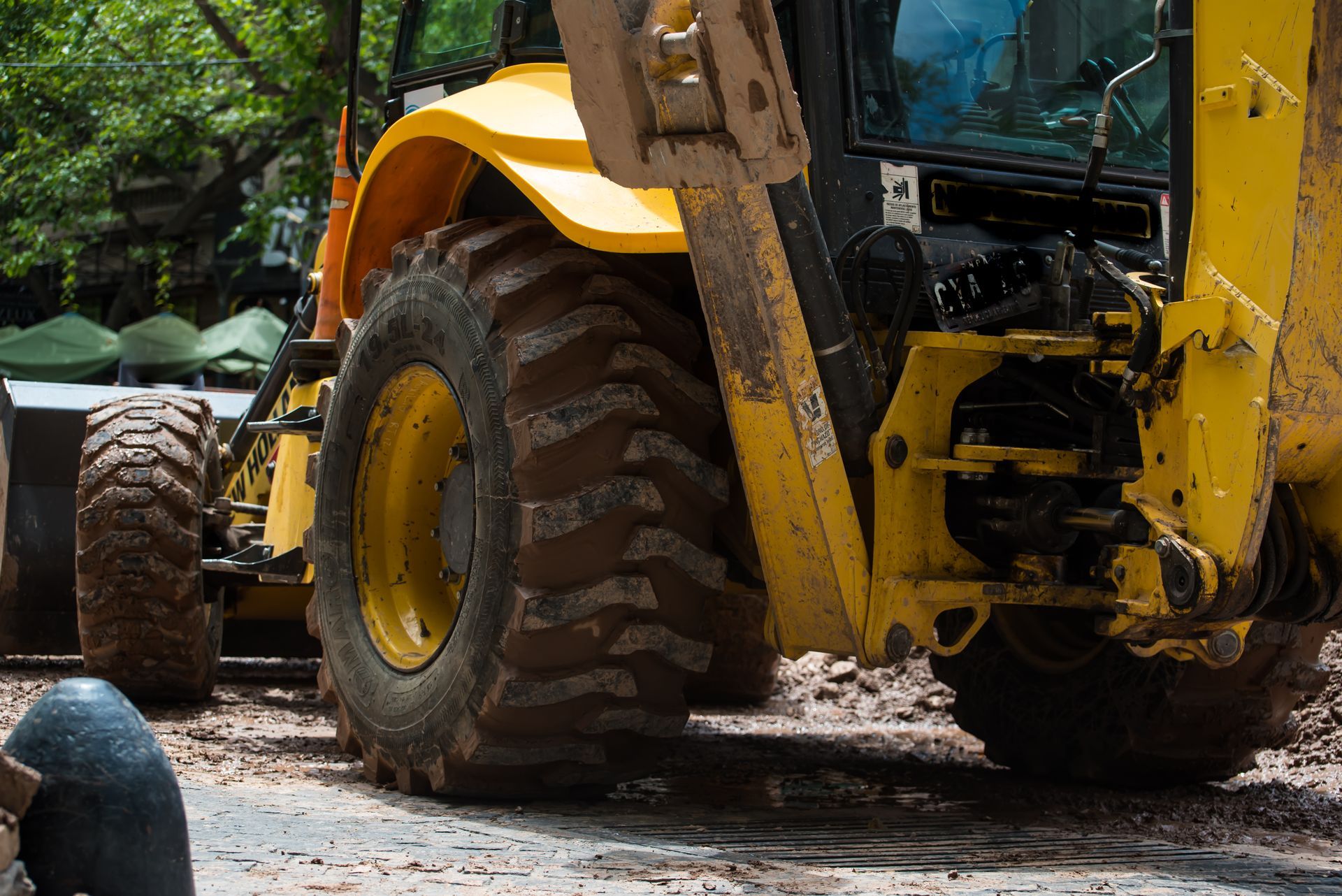 Heavy equipment performing lot cleaning with a yellow loader clearing dirt and debris. 