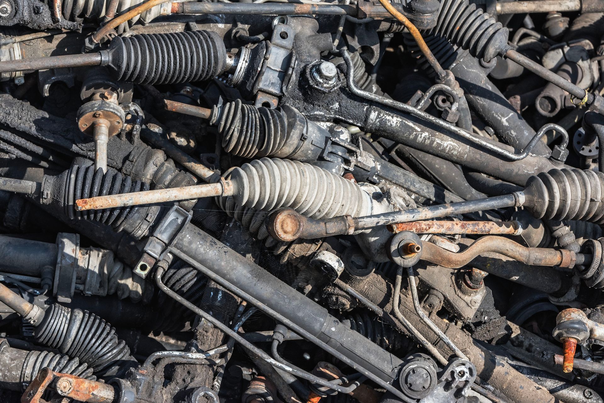 Stacked used auto parts including engines and transmissions in a salvage yard.