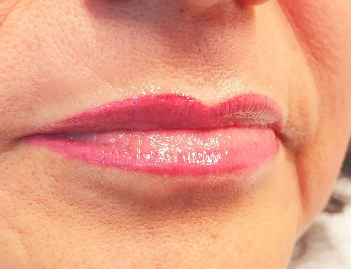 Eine Nahaufnahme der Lippen einer Frau mit rosa Lippenstift.