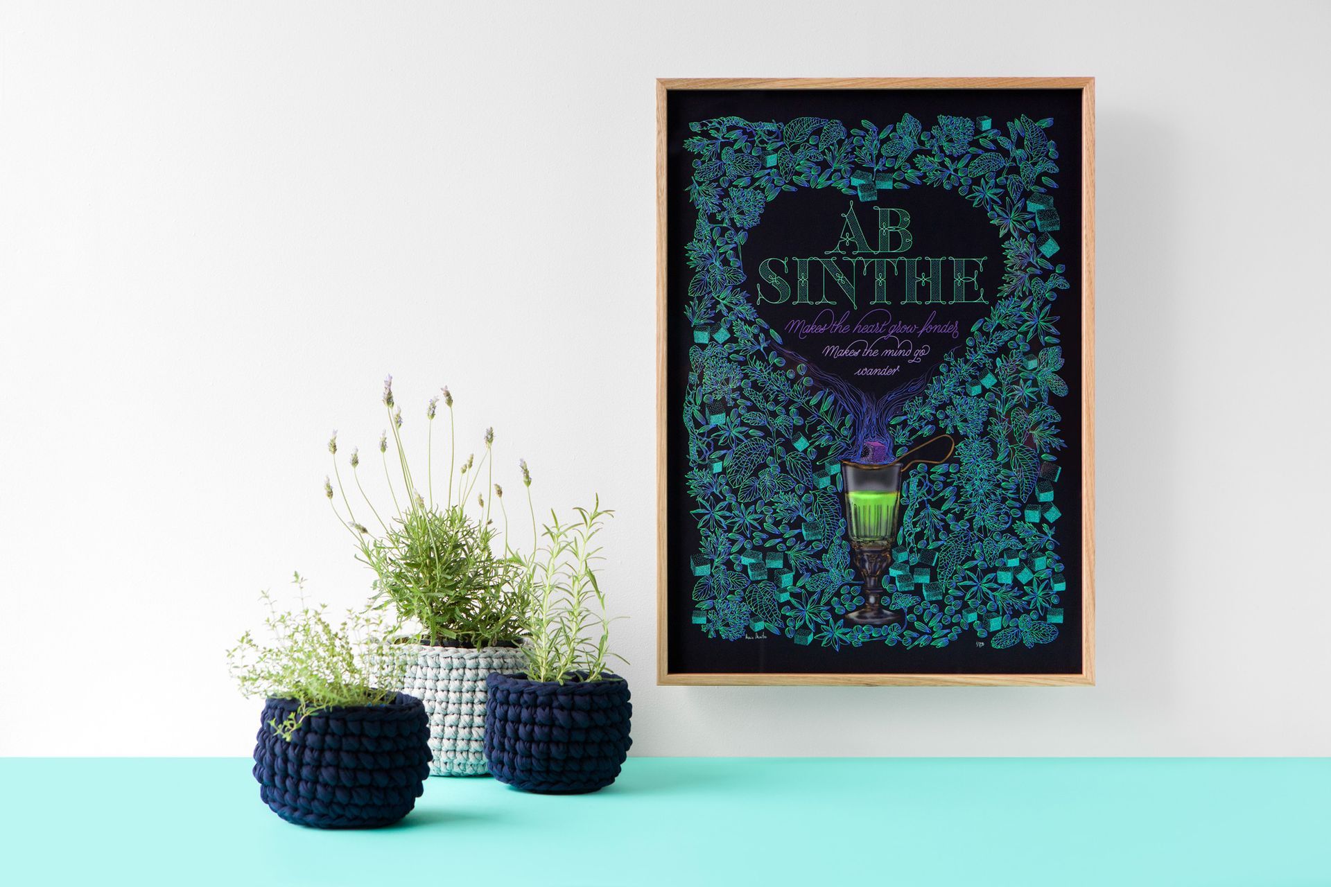Framed teal artwork above two navy planters with white flowers on a light aqua shelf