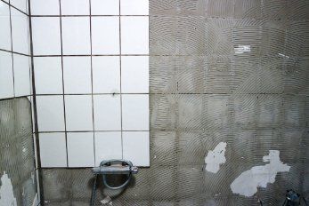 Bare wall of a bathroom under renovation - renovators upgrading the bathroom tiling in Wollongong NSW.