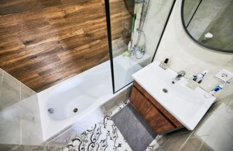 Interior of a small bathroom which undergone a major renovations in Wollongong NSW, including tiling, bathtub, and shower renovation.