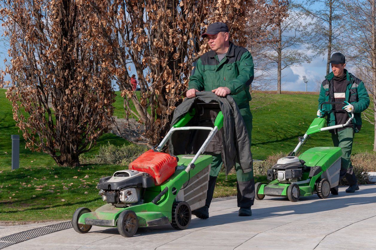 Uniformed male landscapers with lawn mowers for their residential landscaping project - wearing appropriate landscaping uniforms.