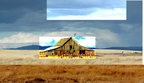 Old weathered barn on a grassy plain under a cloudy sky.