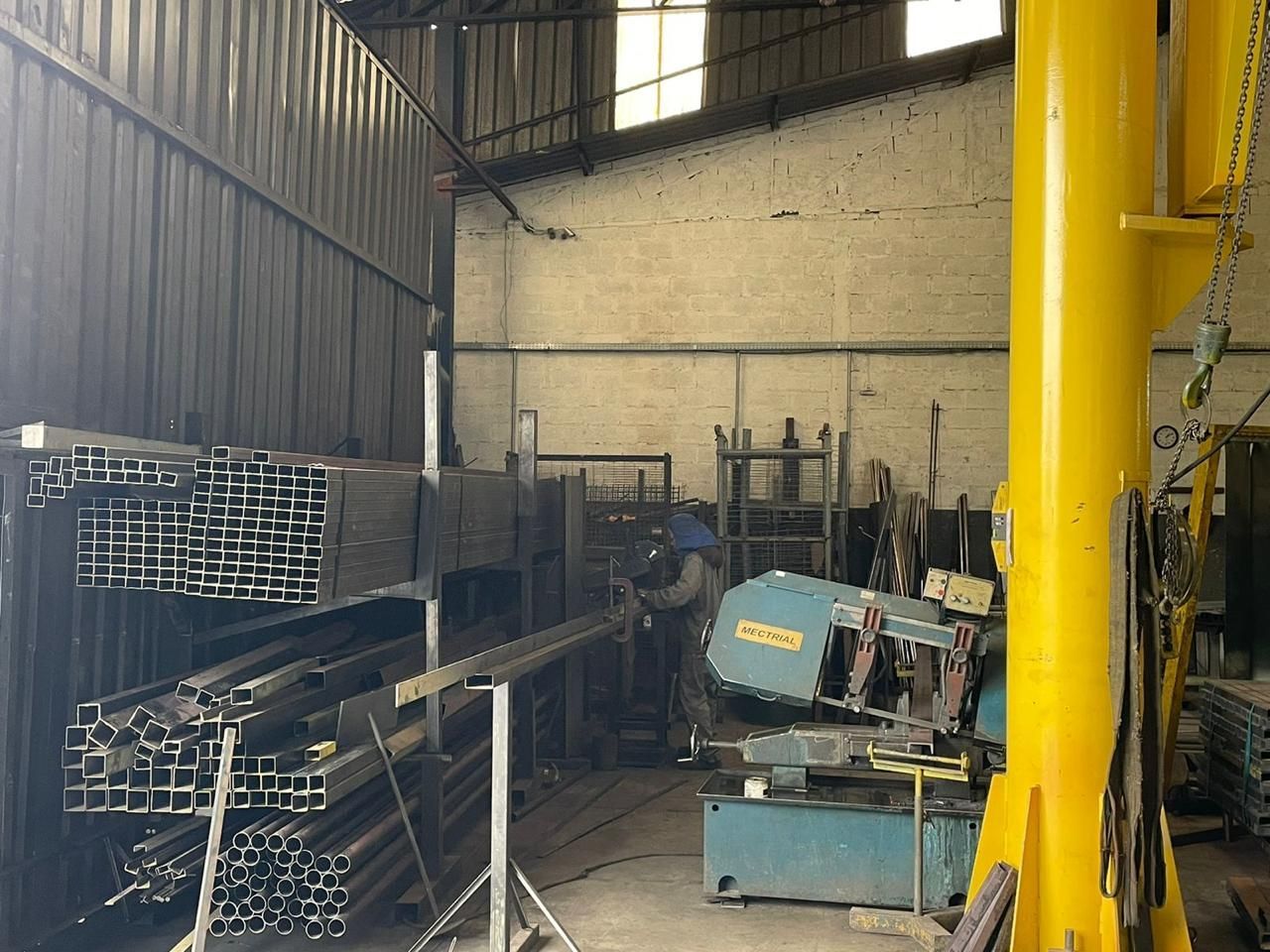 Um homem está trabalhando em uma máquina em uma fábrica.