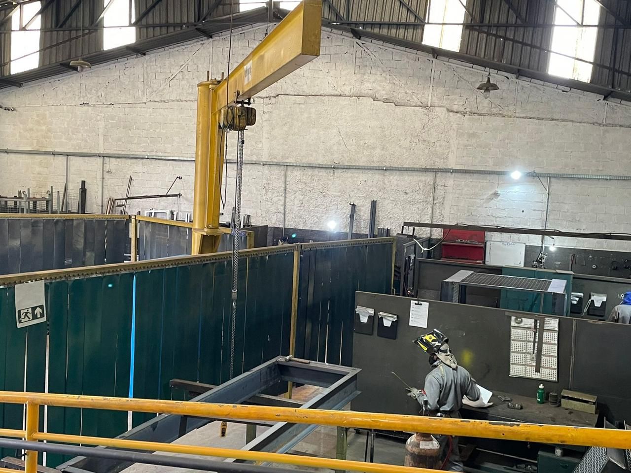 Um homem está soldando um pedaço de metal em uma fábrica.