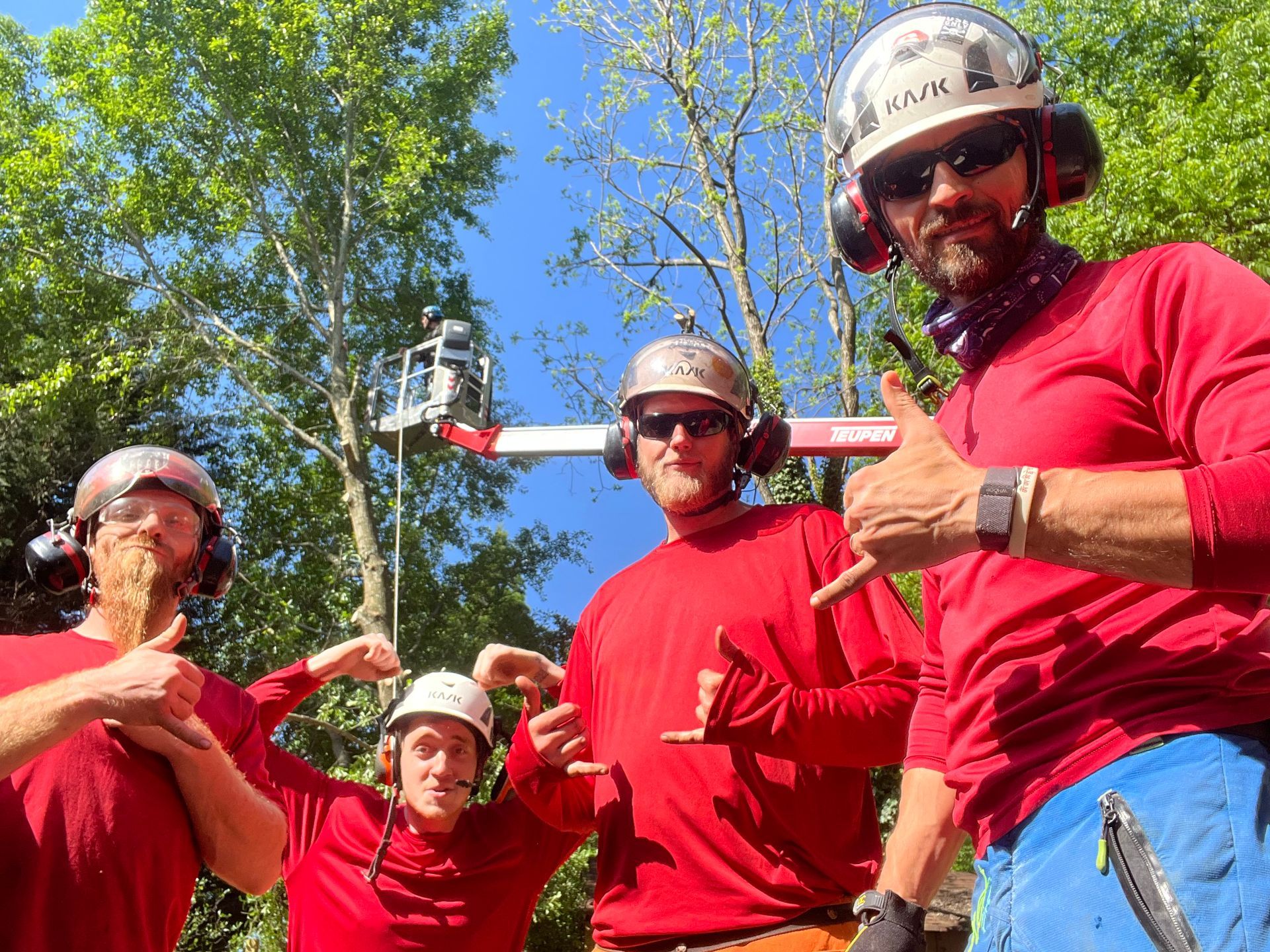A group of men wearing red shirts and helmets are posing for a picture.