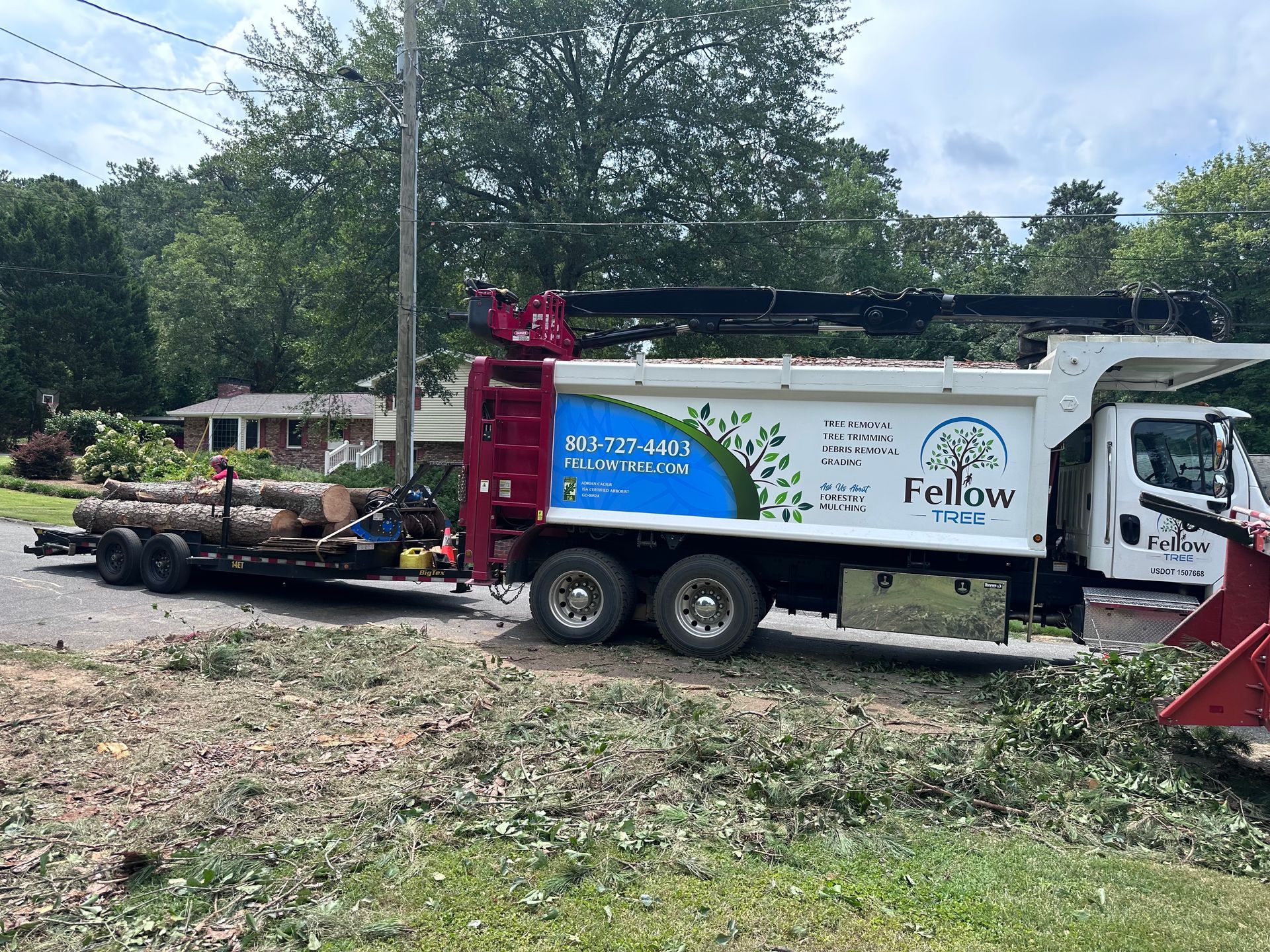 A dump truck is carrying logs on a trailer.