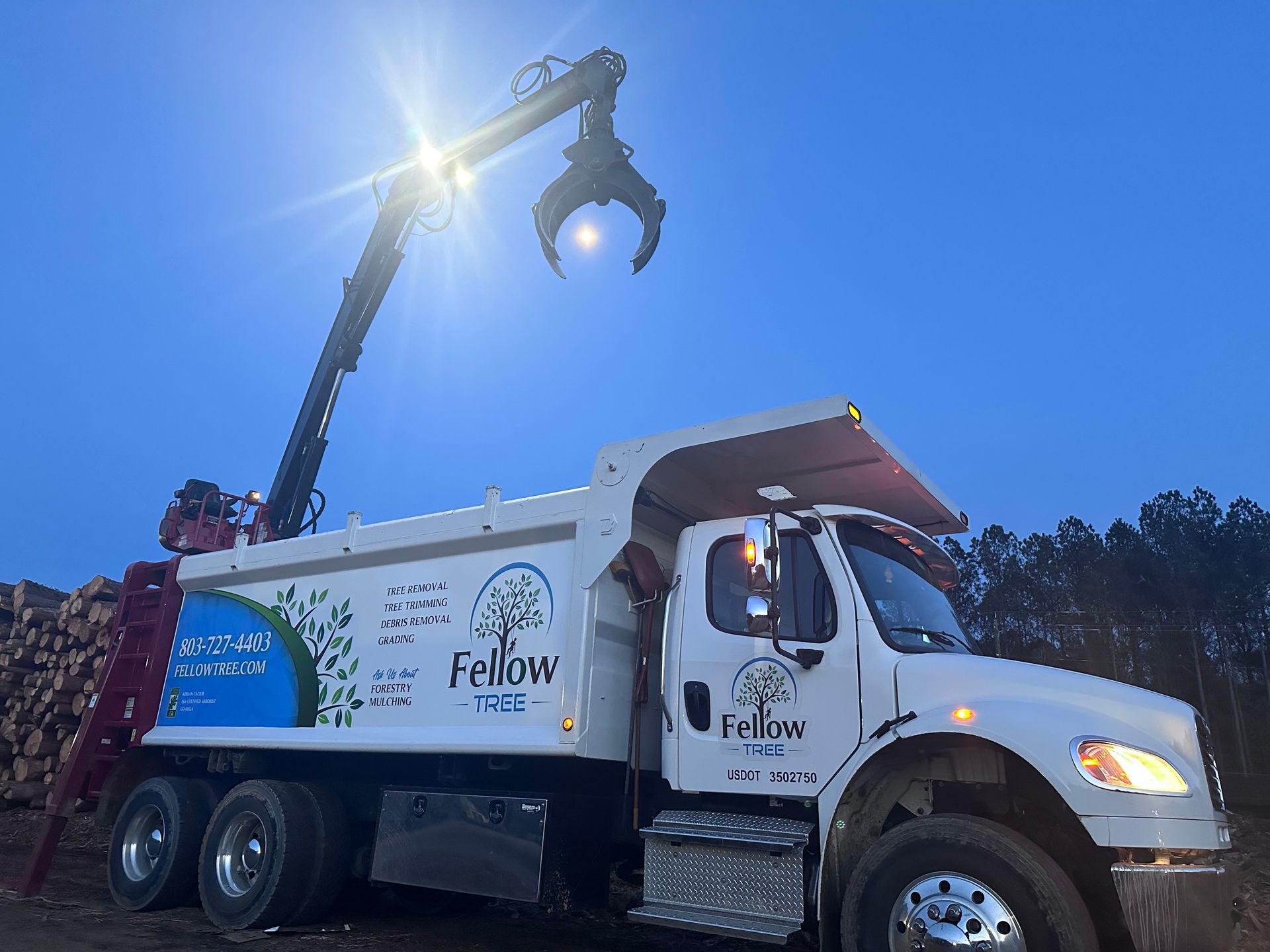 A fellow dump truck with a crane attached to it
