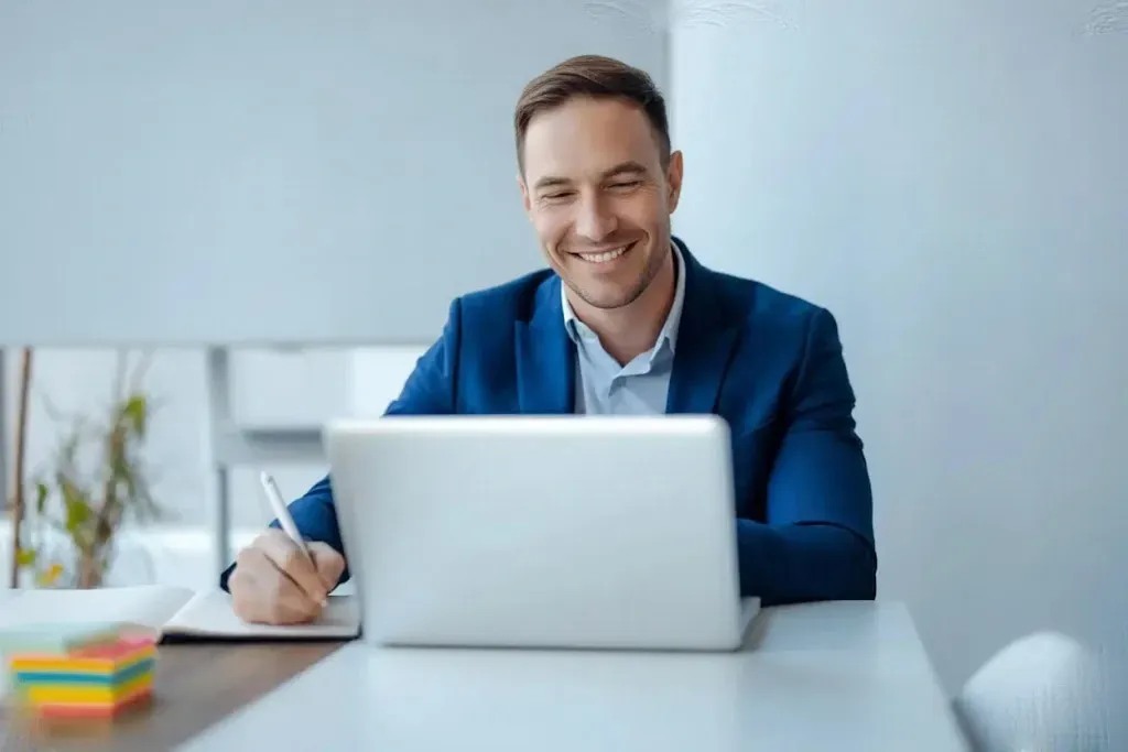 Un uomo in abito blu gesticola mentre parla durante una riunione. 