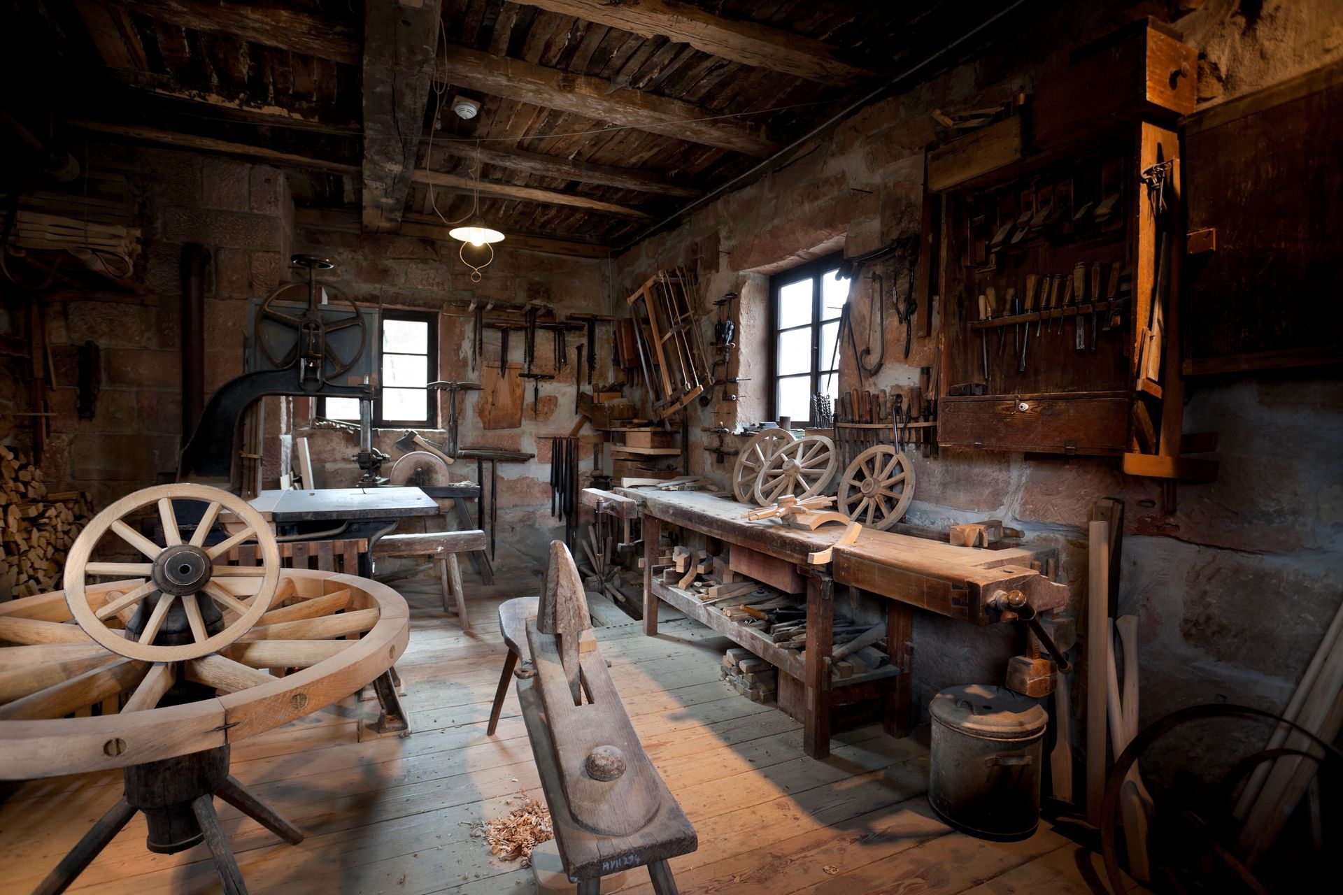 Traditional artisan workshop filled with hand tools and wooden wheels