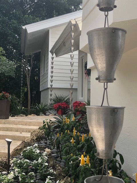 A car is parked under a covered porch in a garage.
