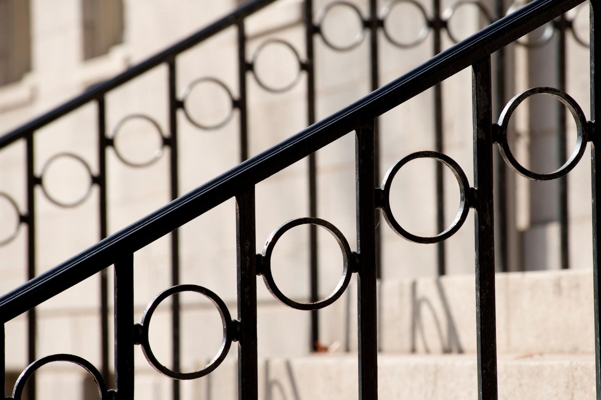 A close up of a wrought iron railing on a set of stairs.