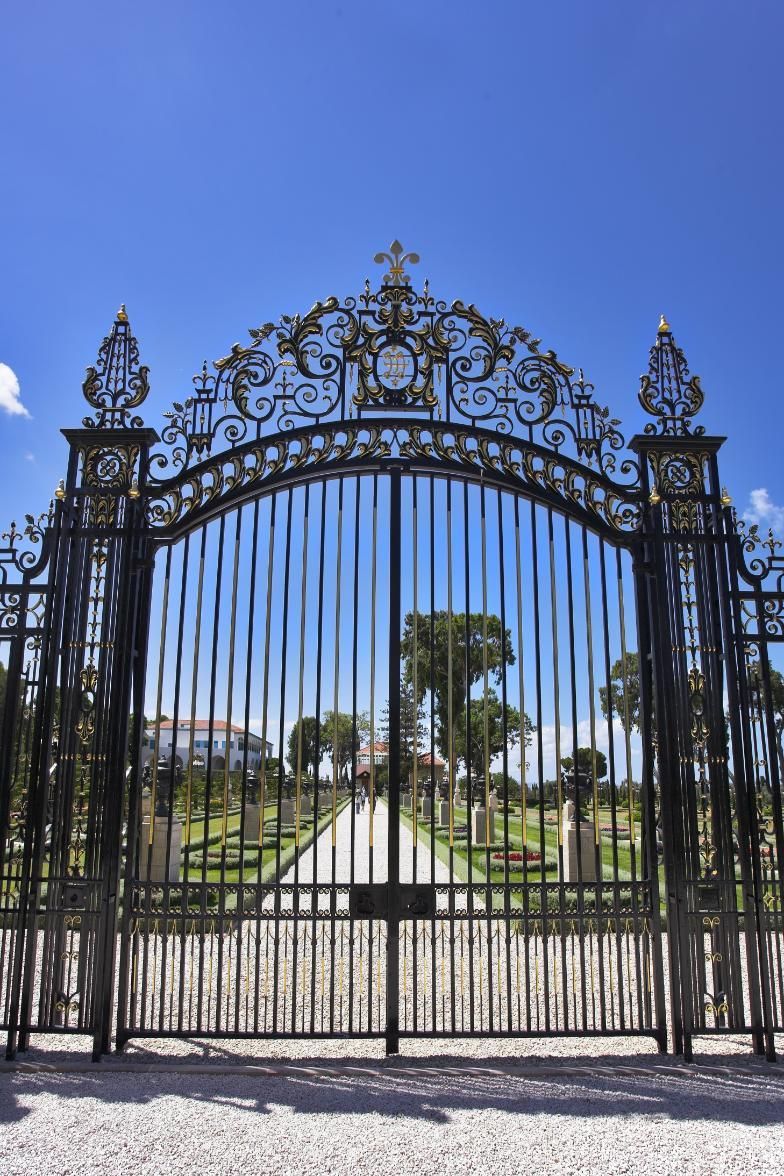 A wrought iron gate with a blue sky in the background.