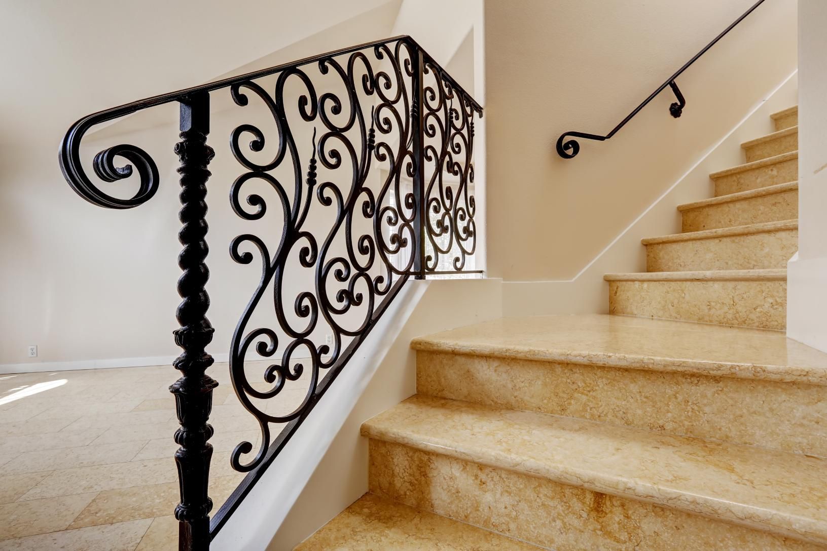 A set of stairs with a wrought iron railing.