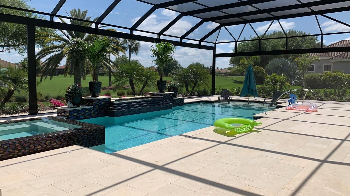 A large swimming pool is covered by a screened in area.