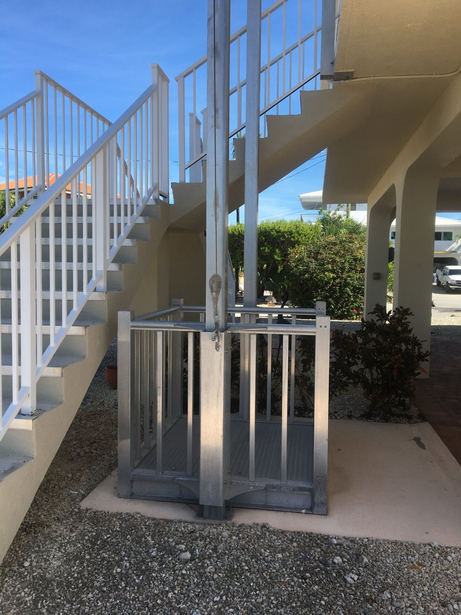 A set of stairs leading up to a house with a wrought iron railing.