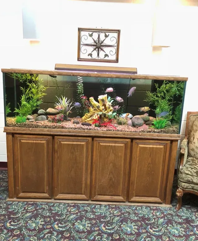 A fish tank is sitting on top of a wooden cabinet.