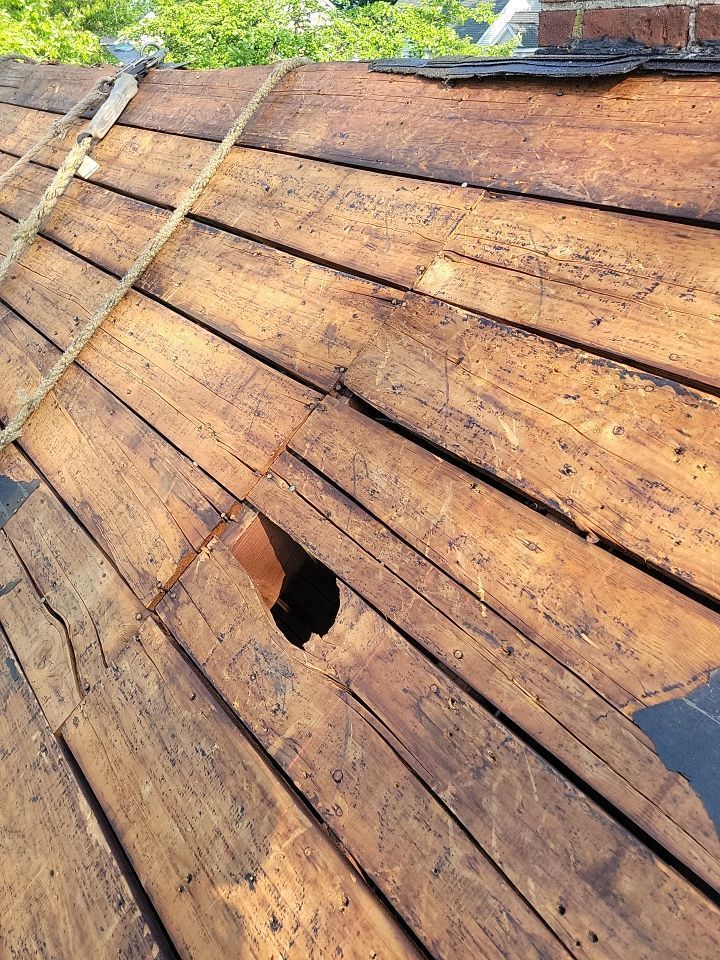 A close up of a wooden roof with a hole in it.