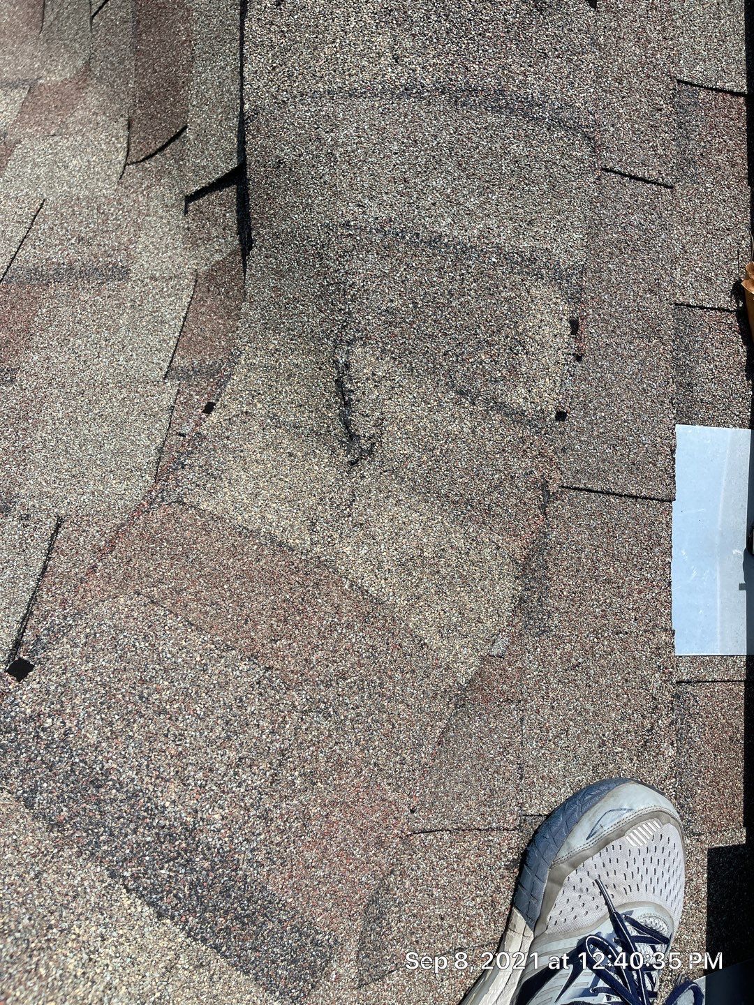 A person is standing on a roof with a pair of shoes on it.