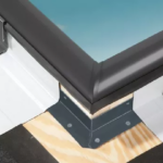 A close up of a corner of a roof with a black trim.