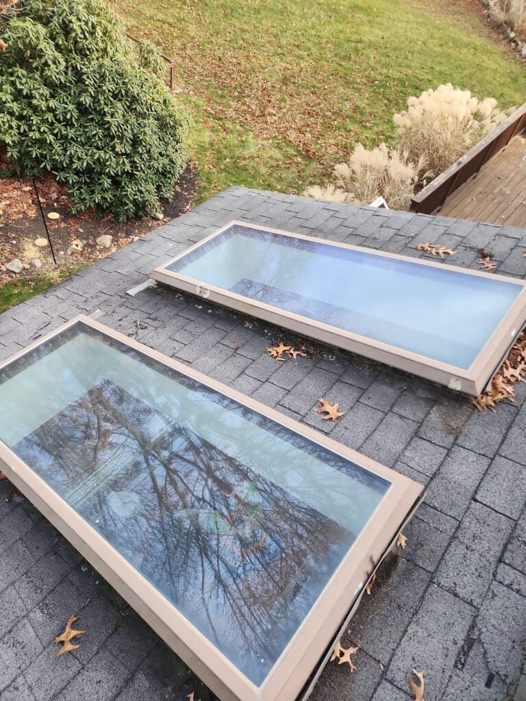 There are two skylights on the roof of a house.