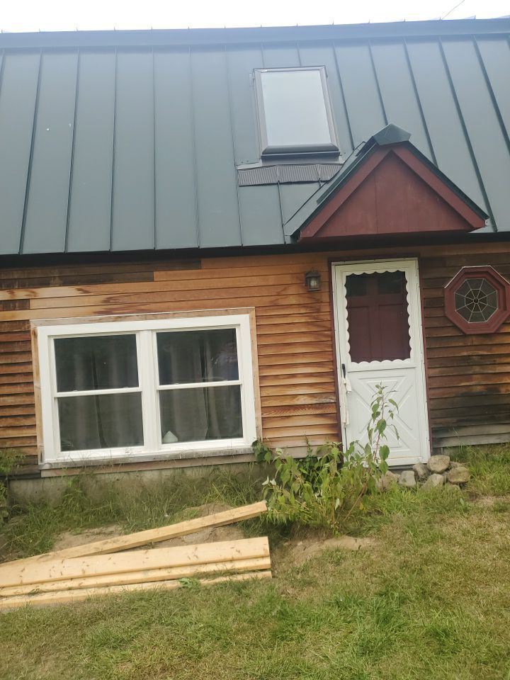 A wooden house with a metal roof and a white door