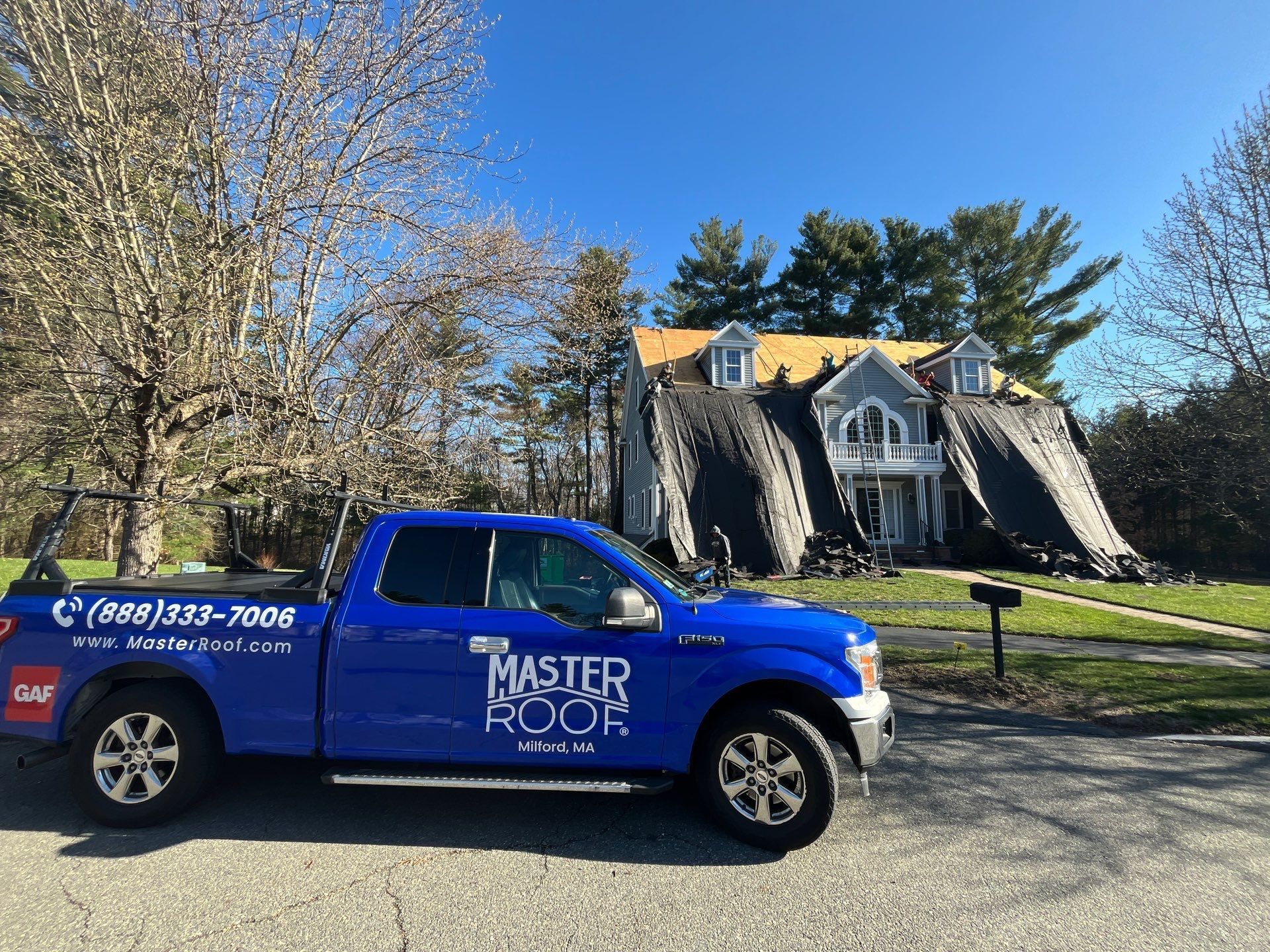 Roofing truck parked in front of a home