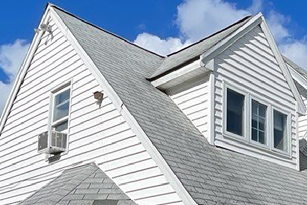 A white house with a gray roof and white siding