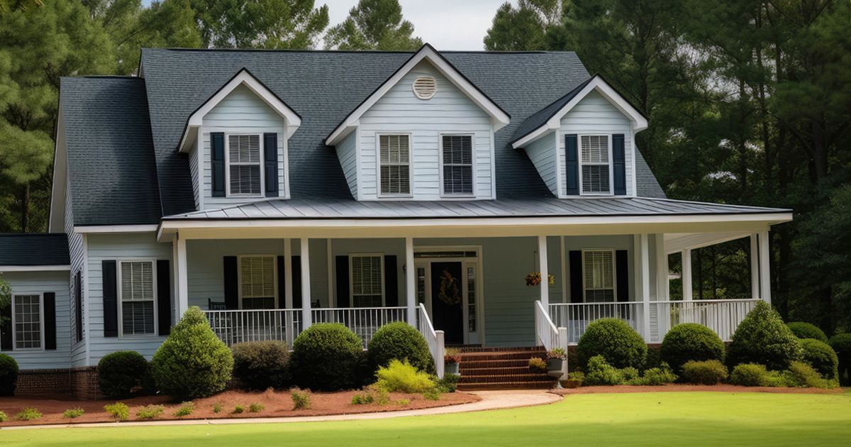 A large white house with a black roof and a large porch.