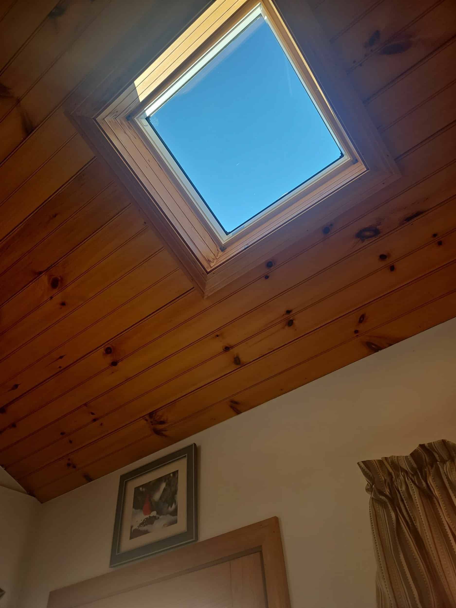 There is a skylight in the ceiling of a room.